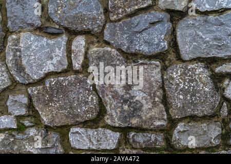 Alte rustikale Steinwand mit hochwertiger Textur und hohem Hintergrund Stockfoto