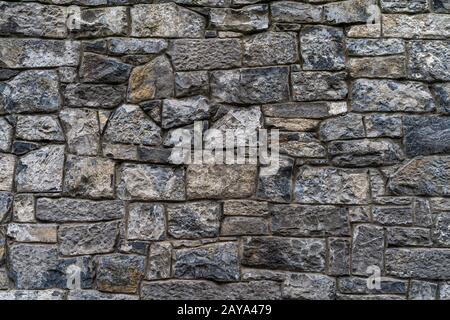 Alte rustikale Steinwand mit hochwertiger Textur und hohem Hintergrund Stockfoto
