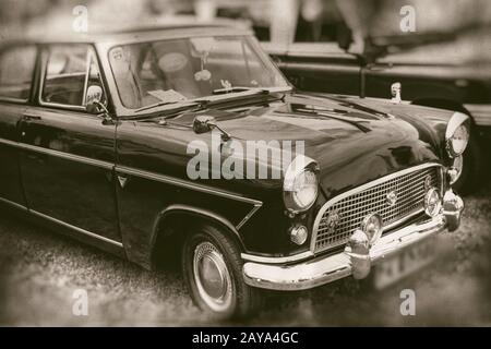 Klassisches schwarzes Oldtimer auf Gras geparkt, Retro-Fotografie Stockfoto