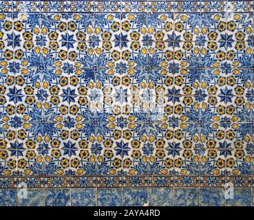 Traditionelle blau-gelbe portugiesische Reifen mit Blumenmuster und glasiertem Keramikdesign mit wiederholtem Design Stockfoto