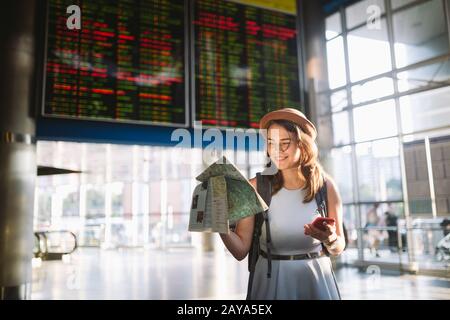 Themenreise und Transport. Schöne junge kaukasische Frau im Kleid und Rucksack im Inneren des Bahnhofs Terminal lo Stockfoto