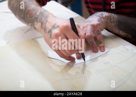 April 2017. Ukraine, Kiew. Die Hände eines Mannes mit einer Filzspitze kennzeichnen die Form einer Schablone auf dem Glas für die Herstellung von gefärbten gla Stockfoto