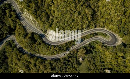 Kurvenreiche Straße im Wald, Luftdronblick, Fahrbahnkonzept. Vogelperspektive. Stockfoto