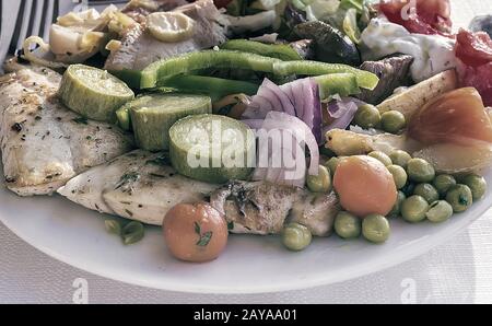 Fleisch, Fisch und verschiedene Gemüsegarnitur auf einem Teller. Stockfoto