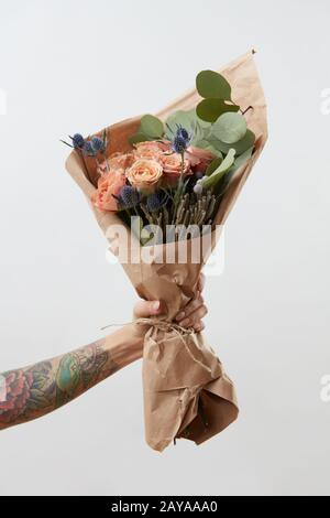 Weibliche Seite zeigt Strauß mit rosa Blüten auf grauem Hintergrund. Geschenk für Mutter oder Frau Tag. Stockfoto