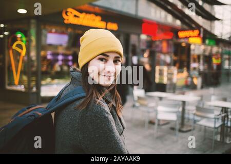 Junge Frau geht durch eine Straße mit Leuchtreklamen. Reisen, Lifestyle und Jugend Konzept. Stockfoto