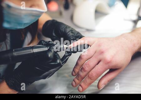 Herrenmaniküre. Professionelle Maniküre für den Menschen mit Maniküre. Ein Mann, der im Schönheitssalon Maniküre erhält. Kosmetikerin mA Stockfoto