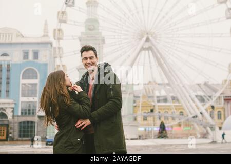 Themenliebe und Urlaub Valentinstag. Paar kaukasische heterosexuelle Liebhaber im Winter zusammen düsteres Wetter umarmen sich gegen B. Stockfoto