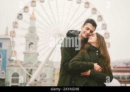 Themenliebe und Urlaub Valentinstag. Paar kaukasische heterosexuelle Liebhaber im Winter zusammen düsteres Wetter umarmen sich gegen B. Stockfoto