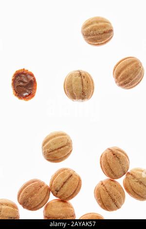 Fallende cookies Walnüsse mit Milch Sahne auf einem weißen Hintergrund. Stockfoto