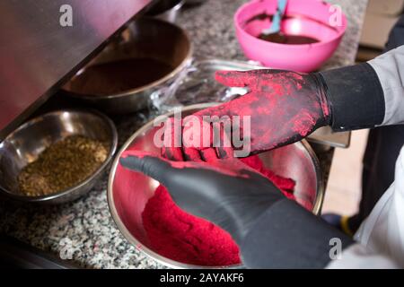 Thema Kochen Schokolade Trüffel. Nahhand Junge kaukasische Frau und Mann kochen mit Tattoo und in Uniform, macht RO Stockfoto