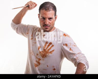 Eine blutige Szene mit einem Mann und einem blutüberzogenen Messer in der Hand isoliert auf weißem Hintergrund. Violen Stockfoto