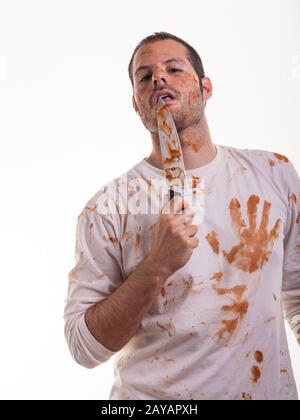 Eine blutige Szene mit einem Mann und einem blutüberzogenen Messer in der Hand isoliert auf weißem Hintergrund. Violen Stockfoto