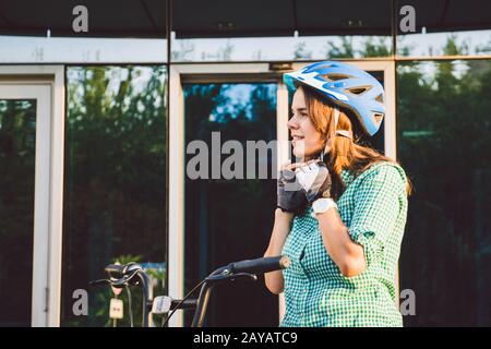 Thema für die Arbeit am Fahrrad. Eine junge kaukasische Frau kam mit einem umweltfreundlichen Transportfahrrad ins Büro. Mädchen in a B. Stockfoto