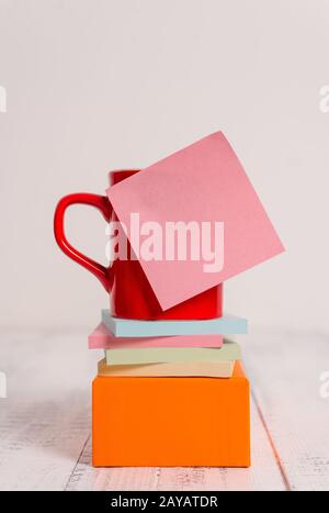 Kaffeetasse mit Vorderansicht, unbeschriftet, klebrig, gestapelt, Notizblöcke, quadratischer Kasten mit Retro-Vintage-Hintergrund, alter Tisch im Landhausstil. Ab Stockfoto