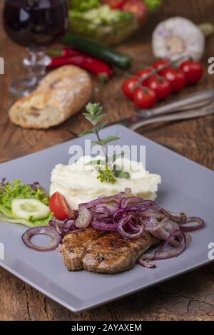 Gegrilltes Schweinesteak mit Zwiebeln Stockfoto