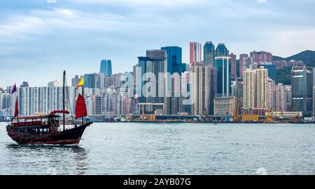 Traditionelle chinesische Dschunke Boot vor der Skyline von Hongkong Stockfoto