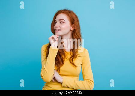 Portrait von Happy Ingwer Rote Haare Mädchen mit Sommersprossen Lächeln auf die Kamera schaut. Pastell-blaue Hintergrund. Platz kopieren Stockfoto