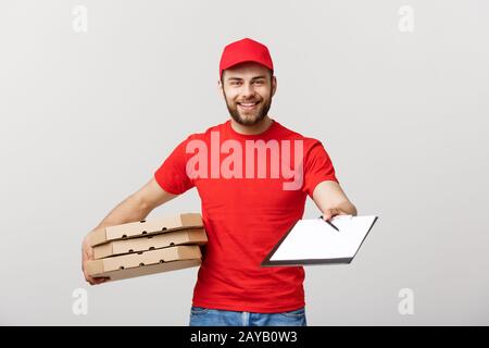 Lieferung Konzept: Junge hübsche Delivery Man mit pizza Kartons geben Ihnen ein Dokument signieren Stockfoto