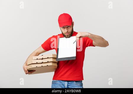 Lieferung Konzept: Junge hübsche Delivery Man mit pizza Kartons geben Ihnen ein Dokument signieren Stockfoto