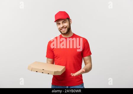 Lieferung Konzept: junge haapy kaukasischen stattlichen Pizza Delivery Man holding Pizzakartons über grauer Hintergrund Stockfoto