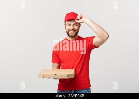 Lieferung Konzept: junge haapy kaukasischen stattlichen Pizza Delivery Man holding Pizzakartons über grauer Hintergrund Stockfoto