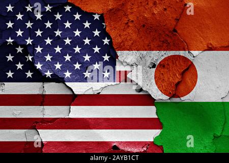 Flaggen der USA und Niger auf gerissene Wand gemalt Stockfoto