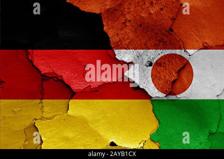 Flaggen von Deutschland und Niger auf gerissene Wand gemalt Stockfoto
