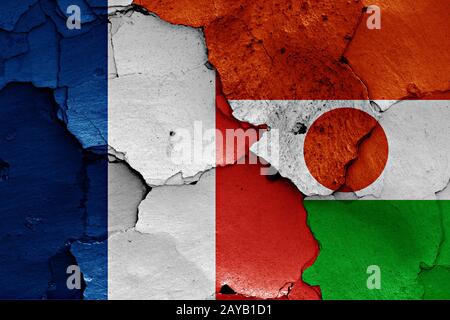 Flaggen von Frankreich und Niger auf gerissene Wand gemalt Stockfoto