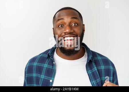 Porträt einer fröhlicher junger Mann schreien mit der Waffe in der Erfolg erhoben. Stockfoto