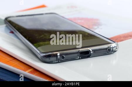 Modernes Smartphone im Hintergrund von Zeitschriften. Stockfoto