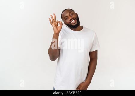 Portrait von Happy african-american man angezeigt ok Zeichen und lächelnd, mit weißem Hintergrund. Stockfoto
