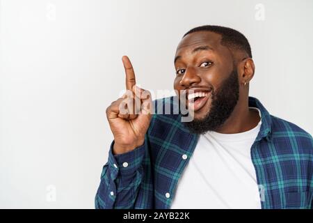 Junge Afrikaner über weißem Hintergrund nach oben zeigend Stockfoto