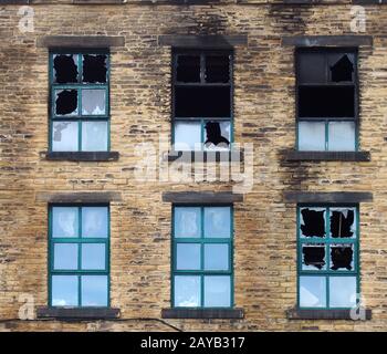 Zerbrochene Fenster in einem großen Industriegebäude brannten nach einem Brand aus Stockfoto