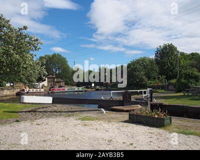 Blick auf die Schleusentore am brighouse Becken am calder und auf den hebbble Navigationskanal mit Lastkähnen und kanalseitigen Gebäuden surrou Stockfoto