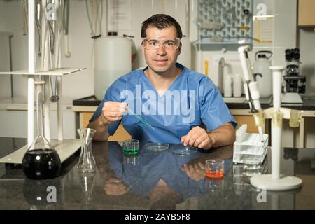 Labortechniker mit mittlerem Alter, Probenahme mit chemischer Lösung für Pipetten im Labor Stockfoto
