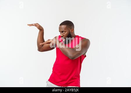 Witzig und verspielt nach African American guy Standing im Profil in der Kampfkunst pose mit angehobenen Palmen, runzelte die Stirn und starrte. Stockfoto