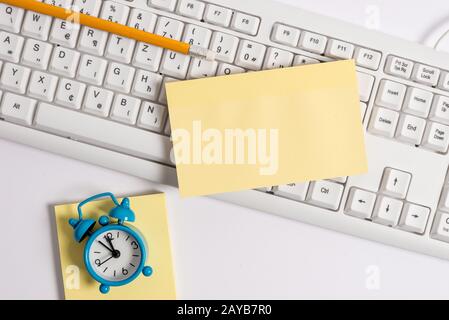 Flach lag über leerem Notizpapier auf den bleistiften und der Uhr der pc-Tastatur. Bild des Geschäftskonzepts mit leerem Notizblatt für Textundurchdralle Stockfoto