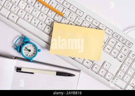 Flach lag über leerem Notizpapier auf den bleistiften und der Uhr der pc-Tastatur. Bild des Geschäftskonzepts mit leerem Notizblatt für Textundurchdralle Stockfoto