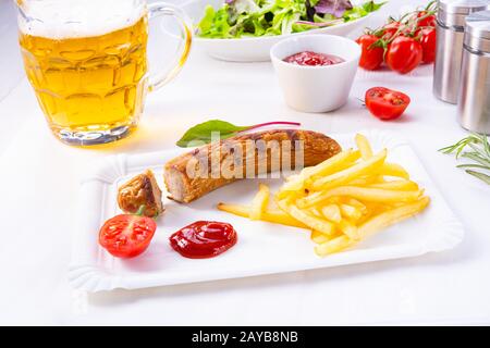 Leckere Bratwurst mit Brötchen und Bier Stockfoto