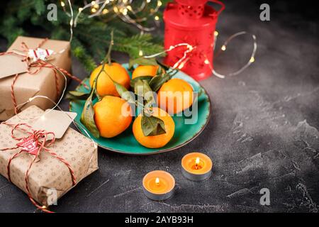 Ansicht von oben eine Tabelle mit Mandarinen, Kerzen und Geschenkboxen Stockfoto