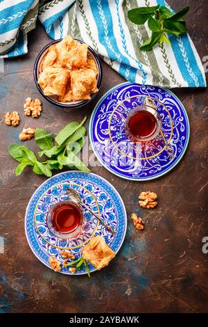 Traditionelle türkische arabische Dessert und einem Glas Tee mit Minze Stockfoto