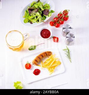 Leckere Bratwurst mit Brötchen und Bier Stockfoto