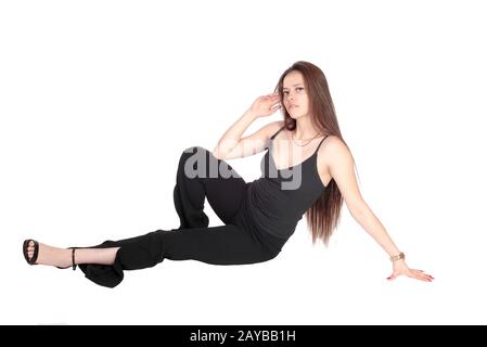 Schöne junge Frau, die im Studio auf dem Boden sitzt Stockfoto