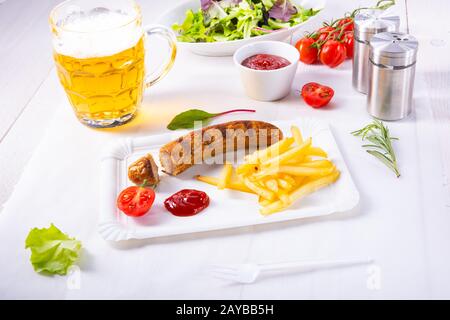 Leckere Bratwurst mit Brötchen und Bier Stockfoto