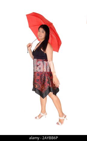 Chinesin steht mit rotem Regenschirm im Studio Stockfoto