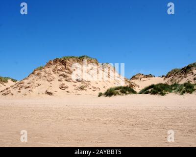 Der Strand von formby merseyside mit hohen Sanddünen, die mit rauem Gras bedeckt sind, und einem blauen, sommerlichen Sonnenhimmel Stockfoto