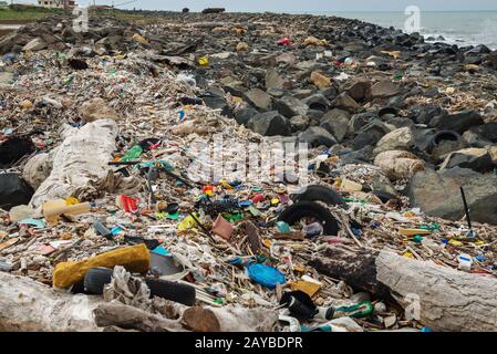 Verschüttete Müll am Strand in der Nähe der großen Stadt. Leere benutzten schmutzige Plastikflaschen und anderen Müll. Stockfoto