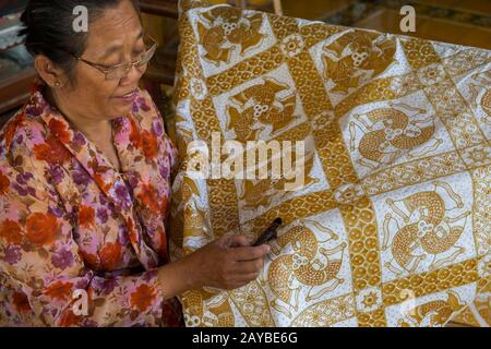 Eine Frau macht traditionellen Batik am Kraton von Yogyakarta (Keraton Ngayogyakarta Hadiningrat), dem Sultans Palastkomplex in Yogyakarta, Java, In Stockfoto