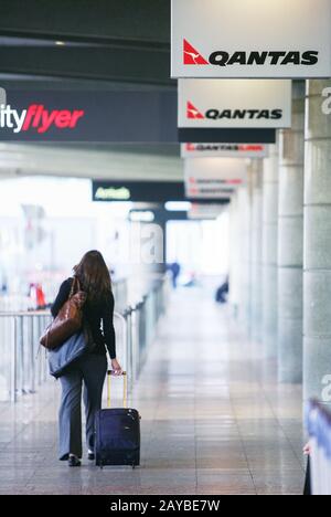 Ein Passagier rollt ihr Gepäck auf dem Inlandsflughafen von Sydney. Stockfoto